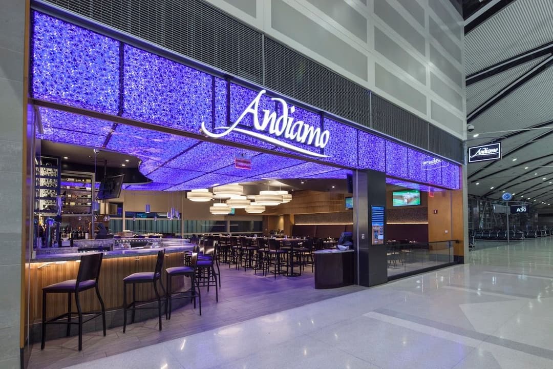 Andiamo restaurant entrance at the airport with blue lighting and modern decor.